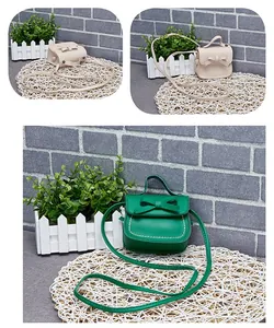 Detail of green and beige mini bow crossbody bags with white stitching on PU leather