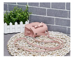Detailed view of pink mini girls shoulder bag with cute bow and matte faux leather