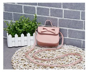Detailed close-up of a pink mini crossbody bag with a bow and white stitching details