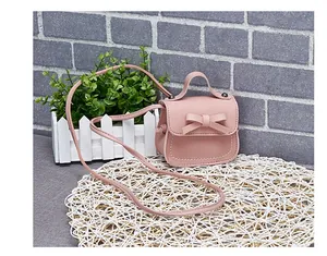Detailed macro view of a pink mini PU leather crossbody bag with a cute bow decoration