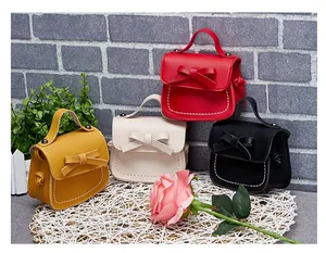 Mini girls' crossbody bags with leather bows in yellow, cream, red, and black colors