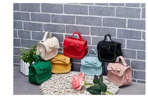 Detail of mini girl bags with bow ties and white stitching in seven pastel colors
