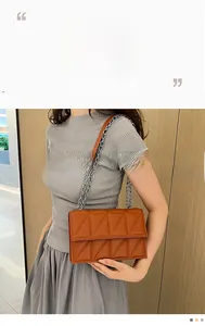 Close-up of brown quilted leather bag with geometric stitching and silver chain strap
