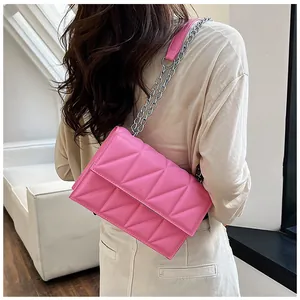 Detail showing pink quilted rhombus texture and elegant silver chain strap on the handbag