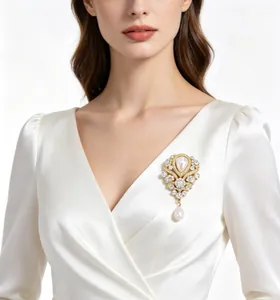 Detail einer luxuriösen Vintage Barockperlen-Brosche mit Strass auf elfenbeinfarbenem Kleid