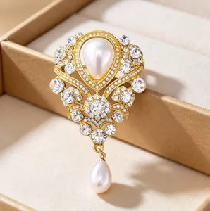 Details einer luxuriösen Vintage-Goldbrosche mit Tropfenperle und klaren Straßsteinen