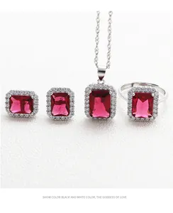 Macro shot of silver jewelry set with emerald-cut red gemstones and diamond halo