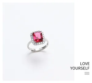 Detailed macro view of silver ring featuring a rectangular pink gemstone with halo diamonds