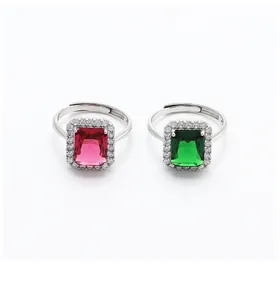 Macro detail of vintage silver rings with emerald and ruby rectangle stones and pavé diamonds