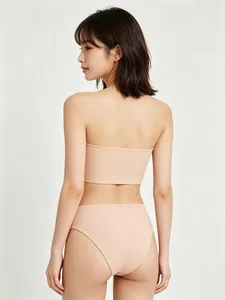 Detail view of skin-tone seamless strapless bandeau and high-waist panties on model
