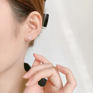 Elegant silver bow earrings with sparkling micro-inlaid cubic zirconia on female model