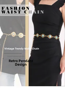 Detail of vintage gold metal waist chain with blue agate stones on black dress