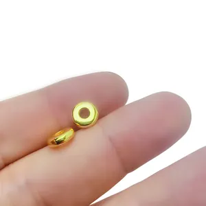 Macro detail of tiny polished gold round spacer beads for DIY jewelry making