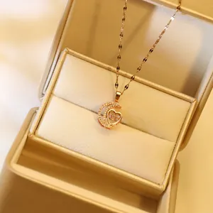 Close-up of golden moon and heart pendant necklace with shimmering zircon in a jewelry box