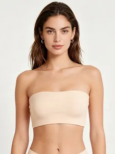 Detail of a seamless beige strapless bandeau bra on a model with high elastic fabric
