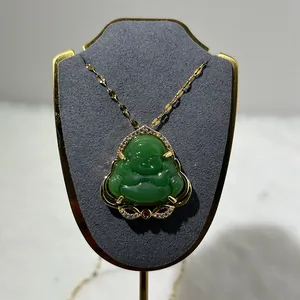 Macro shot of green chalcedony Laughing Buddha pendant with gold inlay and zircons