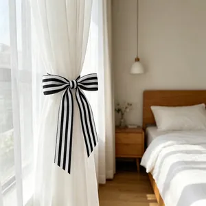 Detail of a black and white striped bow curtain tieback in a modern bedroom setting