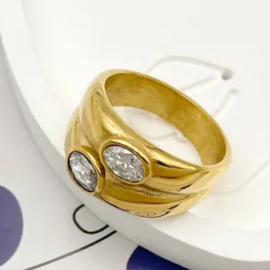Vintage brushed gold stainless steel ring featuring dual oval cubic zirconia stones