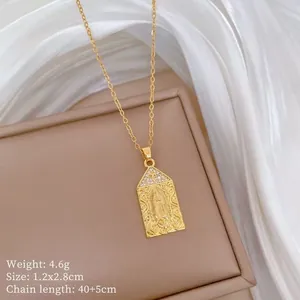 Macro detail of gold Virgin Mary rectangular pendant with cross and crystal inlay