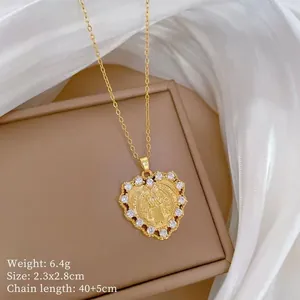 Close-up of gold heart pendant necklace with Virgin Mary relief and zircon stones