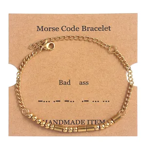 Detail of Morse code bracelet featuring gold beads and tubes on a handmade display card