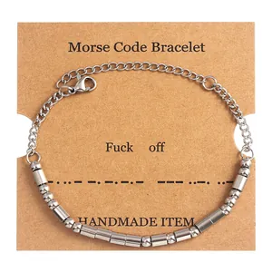 Detail of silver Morse Code bracelet on kraft paper card with Fuck off message engraving