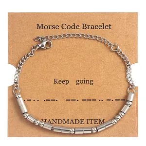 Detail of Morse code bracelet on kraft paper card with Keep Going text and beads