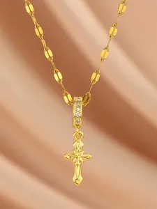 Detail of gold cross pendant with cubic zirconia inlay on vintage hollow chain