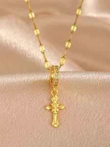 Detail of a vintage gold cross pendant with cubic zirconia bail on a flat link chain