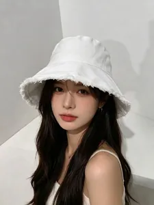 Detailed shot of white cotton bucket hat with frayed edges and flat top design