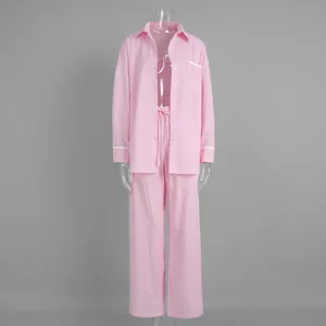 Detail of pink striped pajama shirt with white lace trim on cuffs and lapel collar