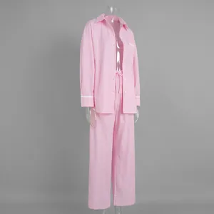Detail of pink striped pajamas set with white lace trim on sleeves and pocket