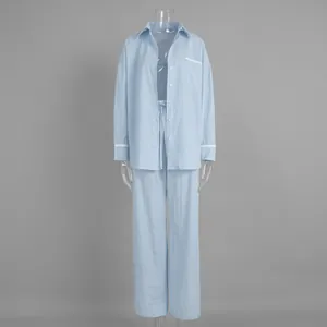 Detail of light blue striped loungewear with white lace trim on sleeves and pocket