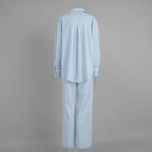 Detail view of striped pajama set showing lace cuffs and back pleat on light blue fabric