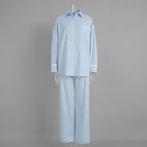 Detail of light blue striped pajama set with white lace trim on sleeves and chest pocket