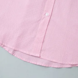 Detail of pink striped shirt showing resin button and curved hemline stitching