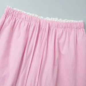 Detail of pink striped pants featuring white lace trim and adjustable drawstring waist