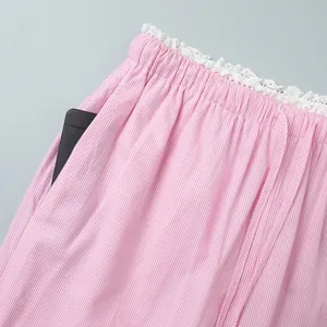 Detail of pink striped pants with delicate lace trim and functional side pockets