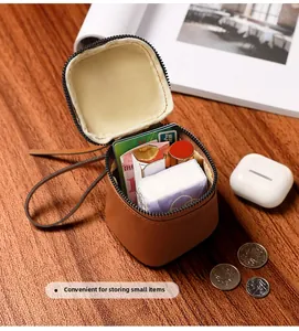 Close-up of brown vintage leather mini round pouch holding lipstick and cards