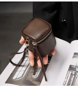 Close-up of deep brown cube-shaped mini coin purse with premium lychee grain texture