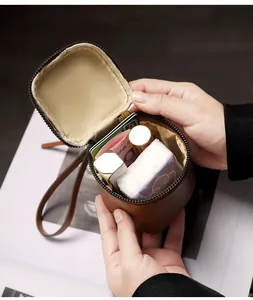 Close-up of compact brown leather cosmetic pouch showing interior lipstick and card storage