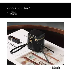 Close-up of black pebble leather mini pouch with gold zipper and long tassel detail