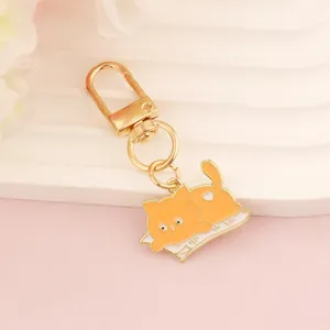 Detail of orange cartoon cat keychain with golden lobster clasp and heart ornament
