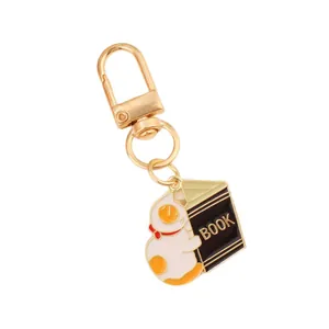 Cute cartoon cat reading a book metal keychain pendant with golden ring for bags