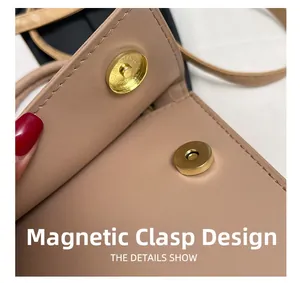 Detail of the magnetic snap closure on a smooth khaki leather crossbody bag