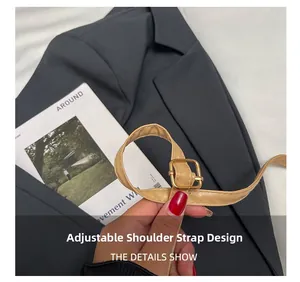 Detail of adjustable light brown leather strap with a gold square metal buckle on a bag