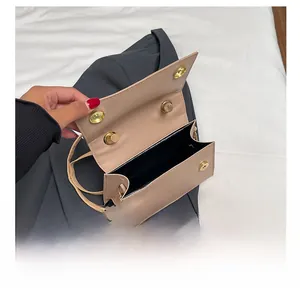 Detail view of the beige crossbody bag interior featuring four gold magnetic metal snaps