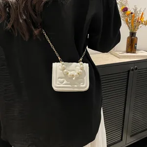 White quilted girl's heart crossbody bag with pearl handle and gold chain strap