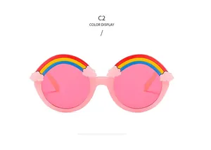 Close-up of pink round kids sunglasses with decorative rainbow and cloud 3D relief