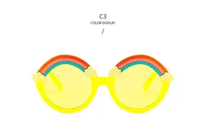 Detail of yellow round frame kids sunglasses with rainbow and cloud decorative elements
